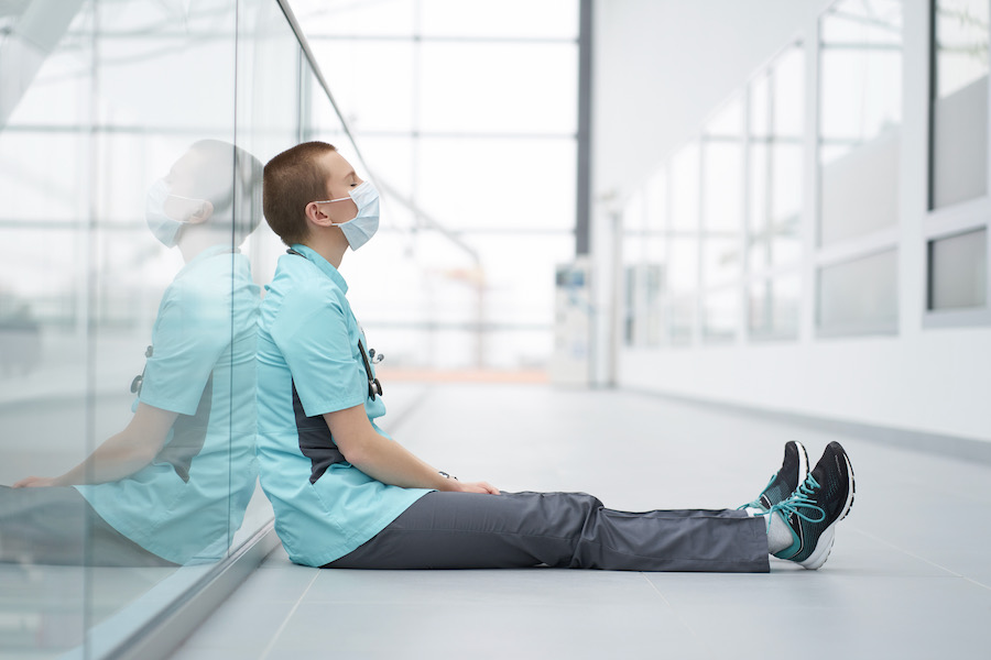 Frustrated healthcare worker sitting on the floor