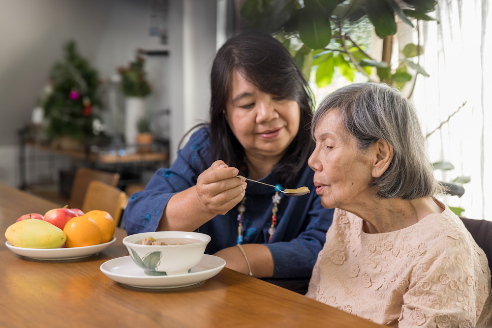 woman feeding elderly woman_Implement IDDSI_Dietitians On Demand