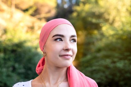 Woman with cancer wearing a pink scarf looking optimistic_Dietitians On Demand