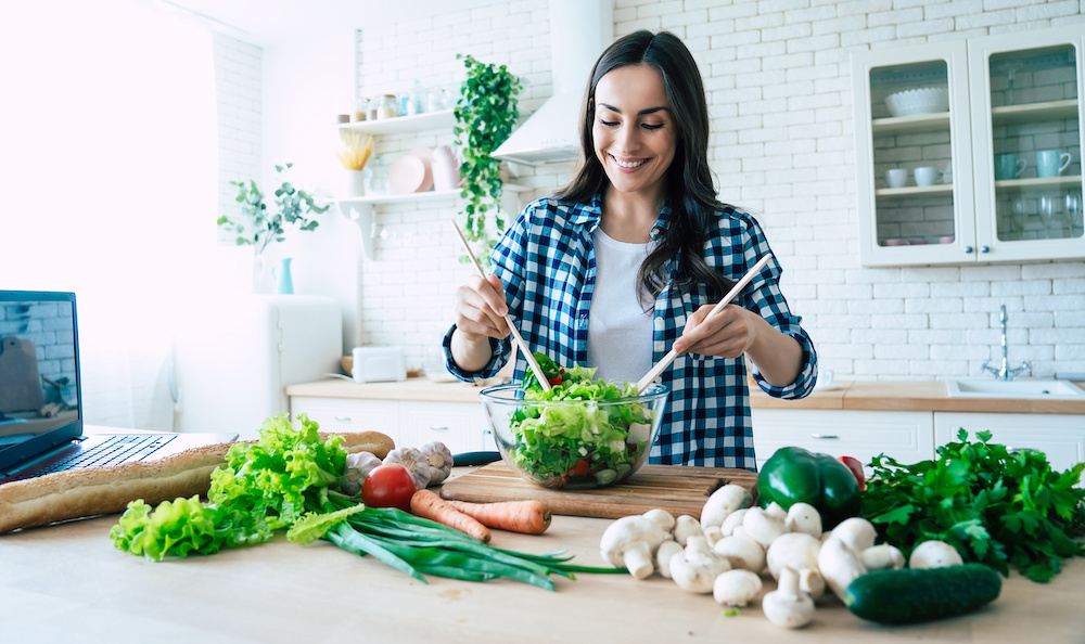 A woman creating a salad in her kitchen