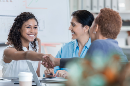 Dietitian and healthcare recruiter shaking hands in a hospital setting, symbolizing a successful nutrition consultant hire through a staffing agency.